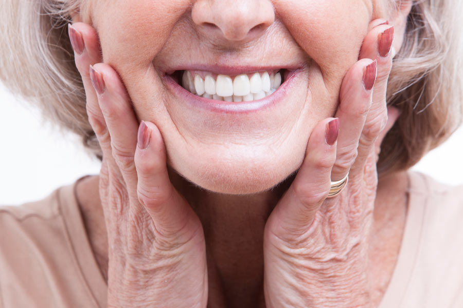 Close up of a lovely mature woman smiling with new dental veneers.