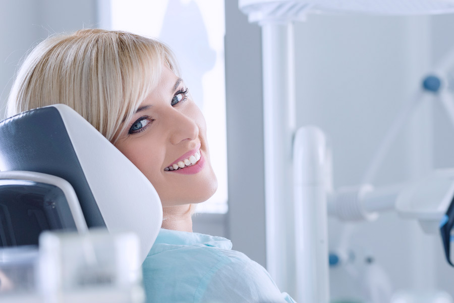 Smiling blonde woman in the dental chair for a cosmetic treatment.