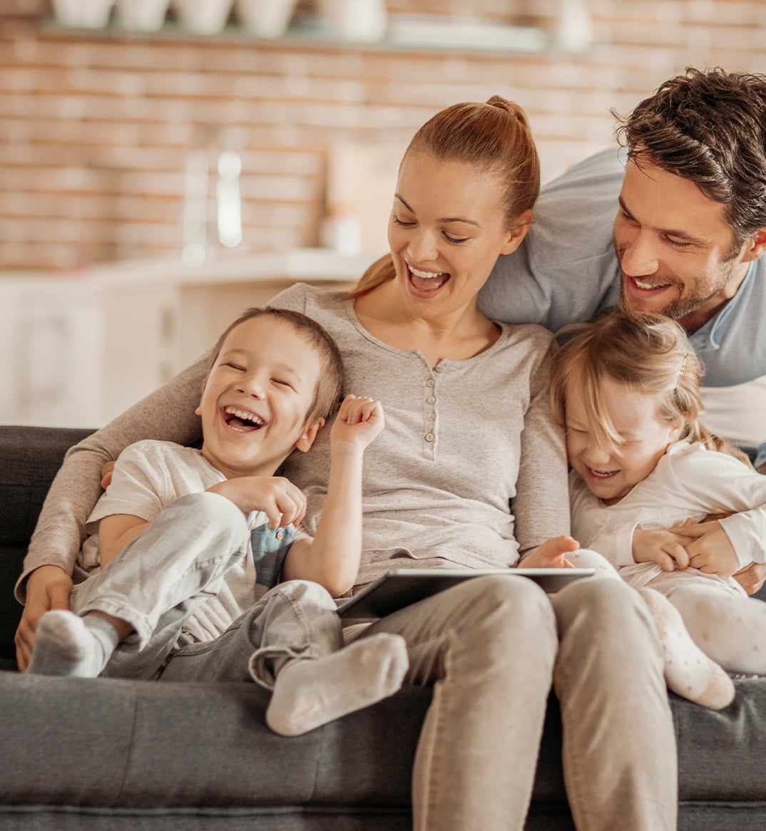 young family reading a book and laughing