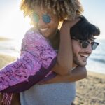 couple on beach after a summer smile makeover at Wagner & Langston Family Dentistry