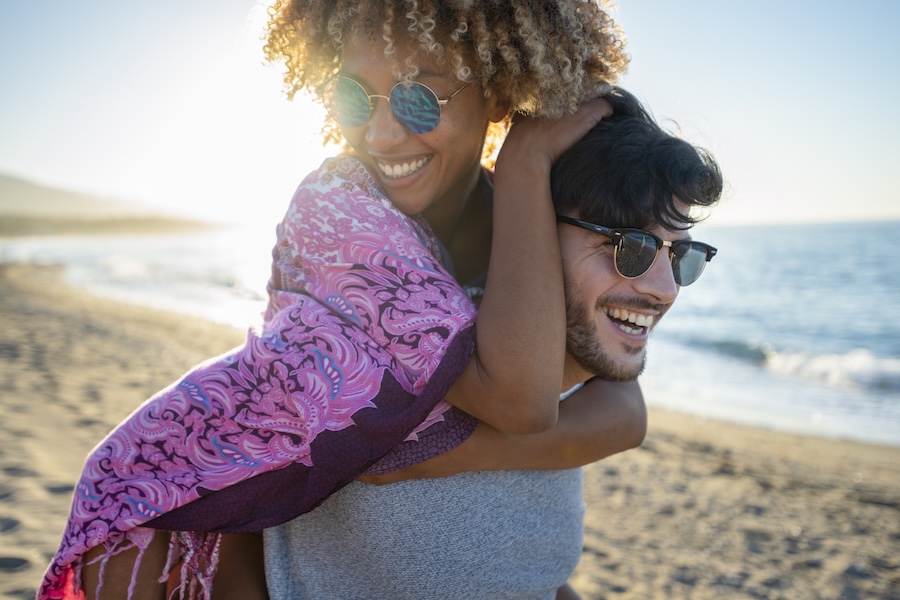 couple on beach after a summer smile makeover at Wagner & Langston Family Dentistry